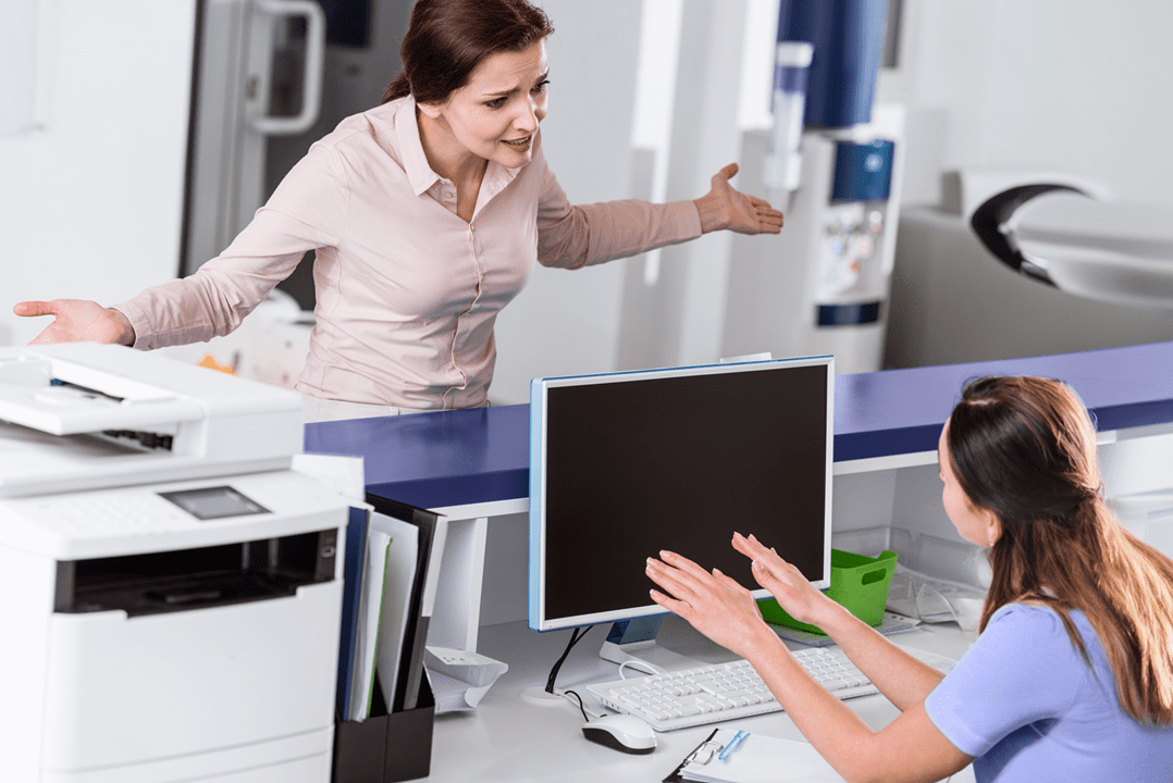Healthcare receptionist applying de-escalation skills to calm down aggrieved patient