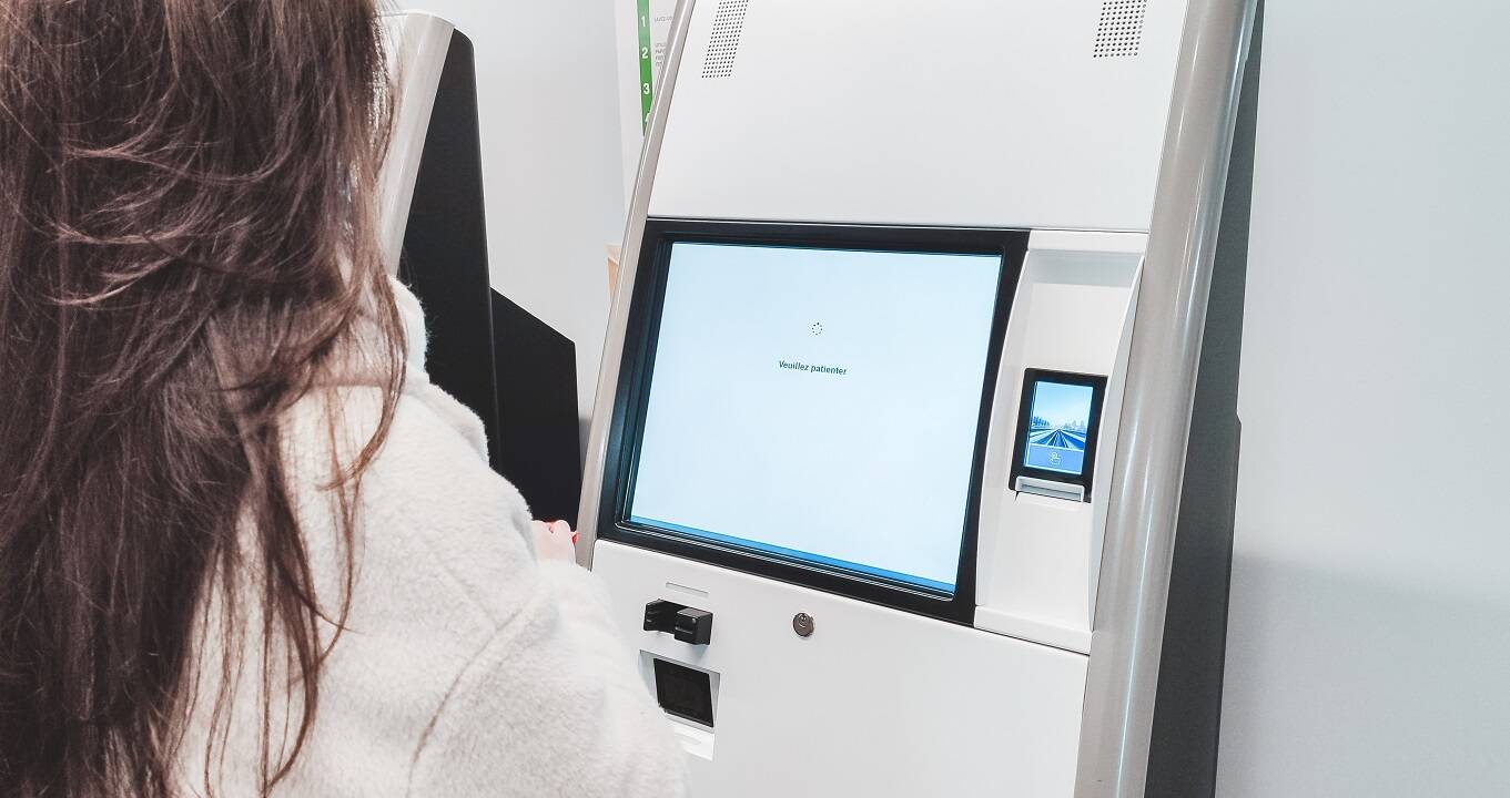 Female patient struggling with self check-in kiosk in clinic