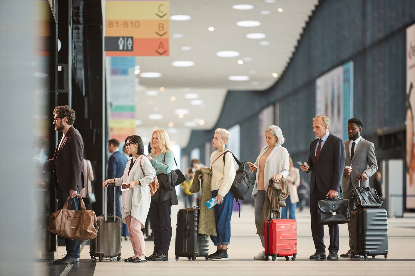 People lining up on the airport front desk receptionist