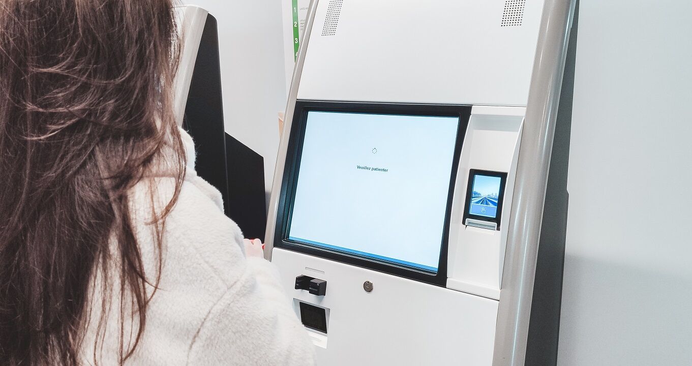 female-patient-struggling-with-self-check-in-kiosk-in-clinic Female patient struggling with self check-in kiosk in clinic