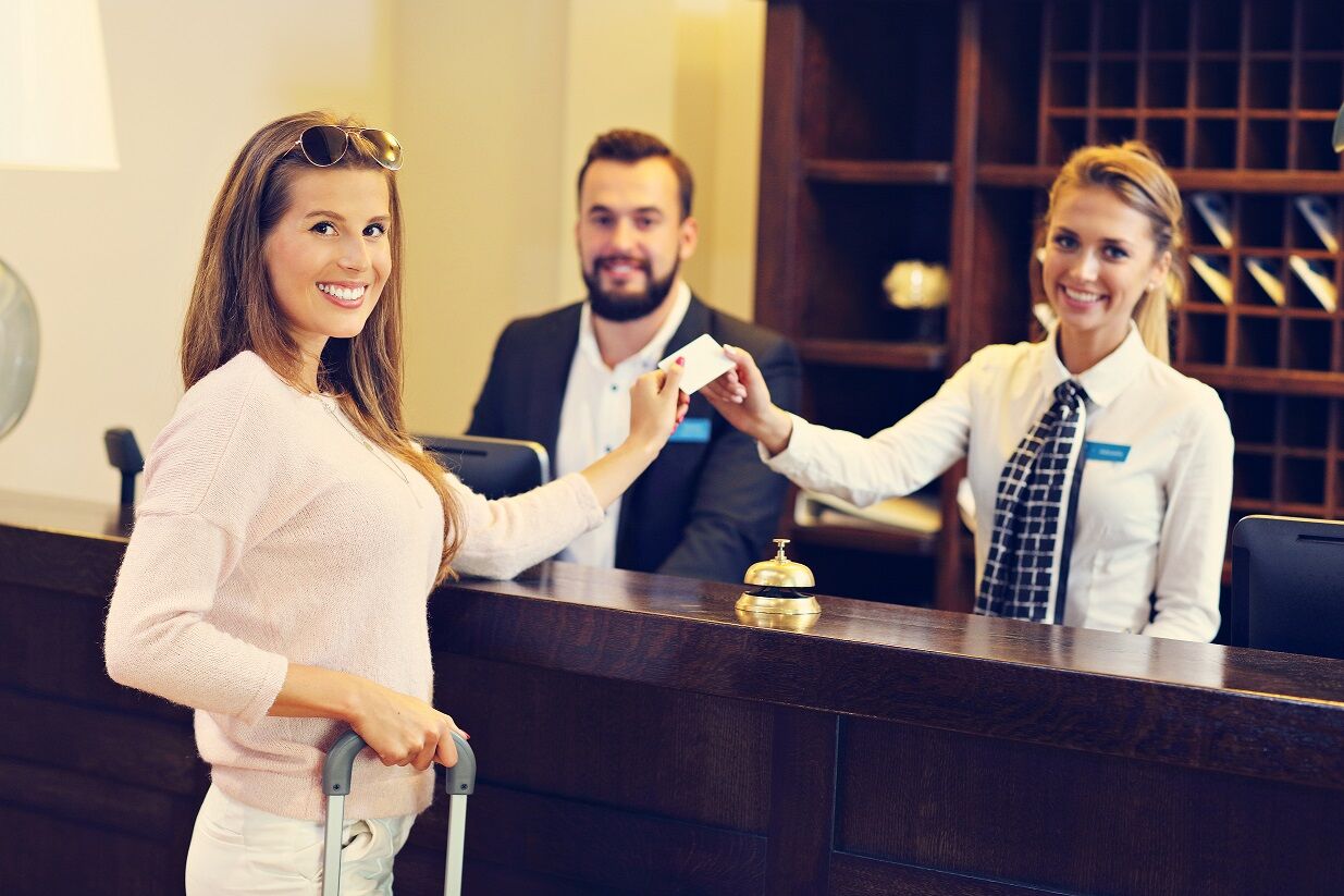 Woman at reception desk in hotel Hotel receptionist assisting the guest
