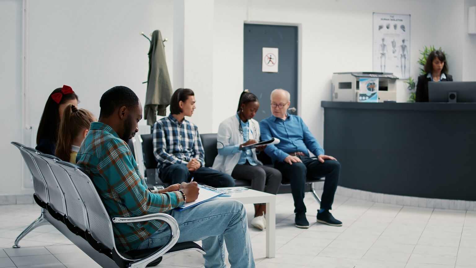 Diverse group of patients sitting in waiting room at hospital Patients in the waiting room area
