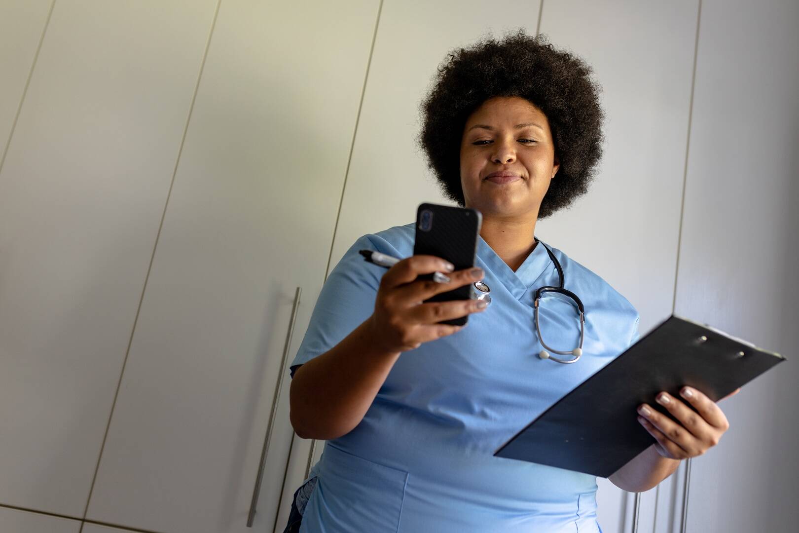 Medical receptionist sending patient reminder through phone text